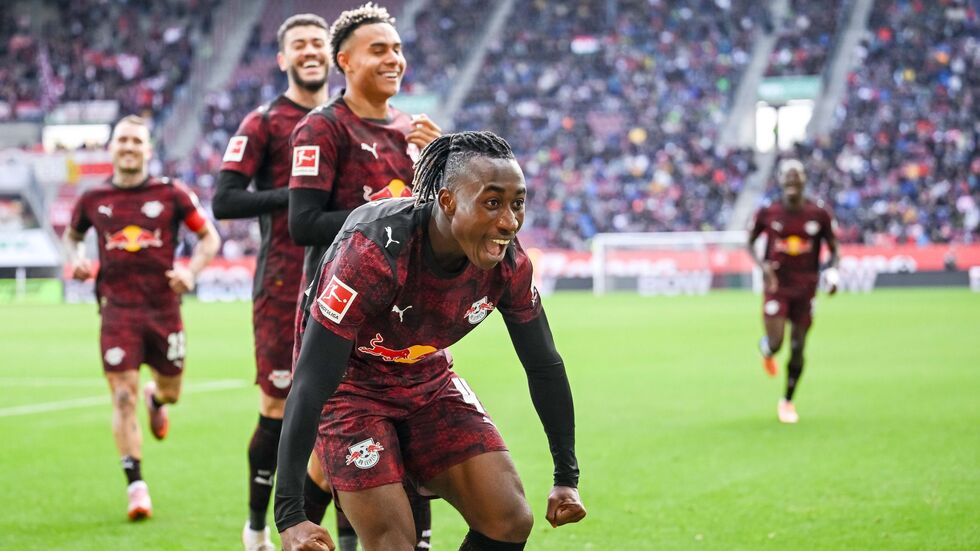 Glückliche Leipziger, vorne 1:0-Schütze Yan Diomande, jubeln in Augsburg.