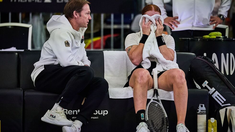 Ella Seidel vergräbt ihr Gesicht hinter einem Handtuch - Teamchef Rainer Schüttler tröstet.