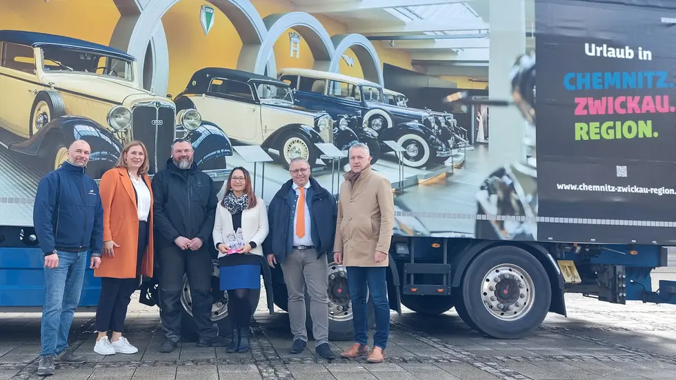 Die Protagonisten vor dem bedruckten Lkw.