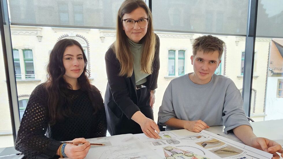 Baubürgermeisterin Silvia Queck schaut Emma Jenkner und Lennox Schiecke über die Schulter.