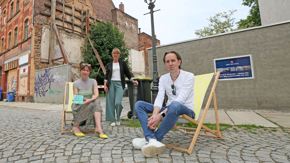 Designerin Sara Linke (v.l.), Stadtmanagerin Anne Kuhl und Egghead-Betreiber Matthias Werler vor der Betonwand, die zur Liebesmauer werden soll.