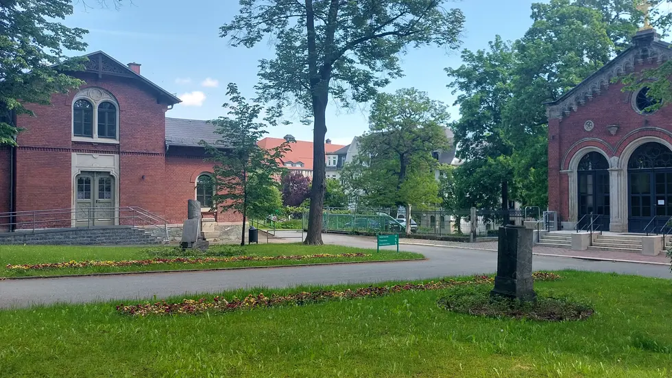 Die beiden Stelen und die Blumenbeete markieren den Ort des ältesten Massengrabs der Stadt.
