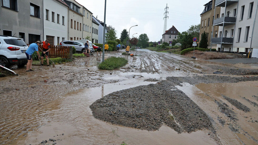 Anwohner am Dittrichbach rücken dem Schlamm zuleibe.