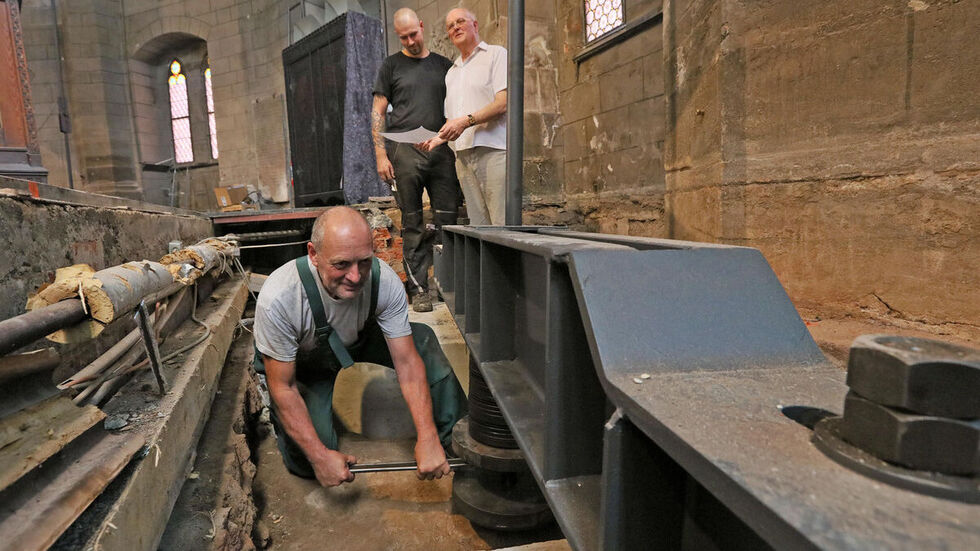 Metallbauer Gunter Illing (vorn) und Peter Winkler (hinten links mit Dombaumeister Michael Kühn) beim Montieren der Halterungen für die Zugstangen. © Ralph Köhler/propicture Metallbauer Gunter Illing (vorn) und Peter Winkler (hinten links mit Dombaumeister Michael Kühn) beim Montieren der Halterungen für die Zugstangen. © Ralph Köhler/propicture