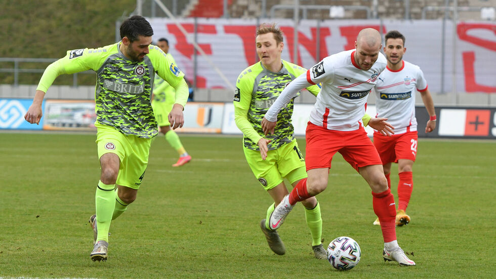 FSV-Routinier Manfred Starke im Laufduell mit den beiden Wiesbadenern Sascha Mockenhaupt und Marc Lais