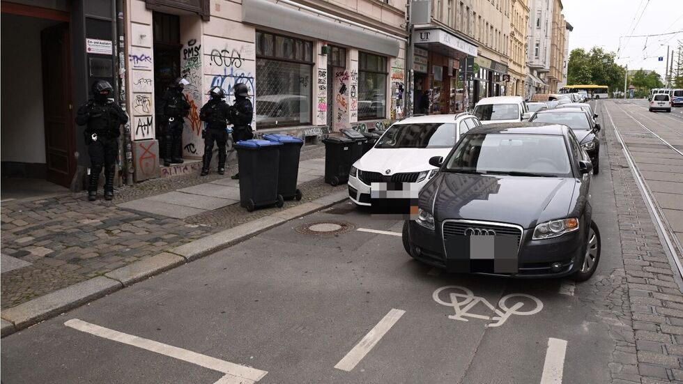Mehrere vermummte Beamte bewachen einen Hauseingang an der Wolfgang-Heinze-Straße.