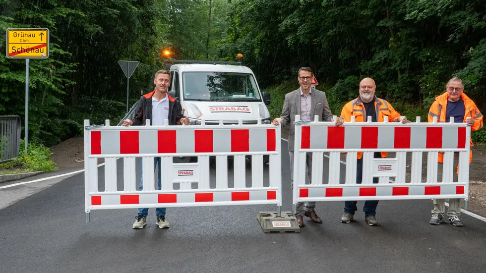 v.l.: Frank Leppelmeier (Strabag), Mario Müller (Beigeordneter), Sandro Wichmann (Straßenmeister) und Dieter Dähn (Amt für Straßenbau) entfernen die letzte Bake.