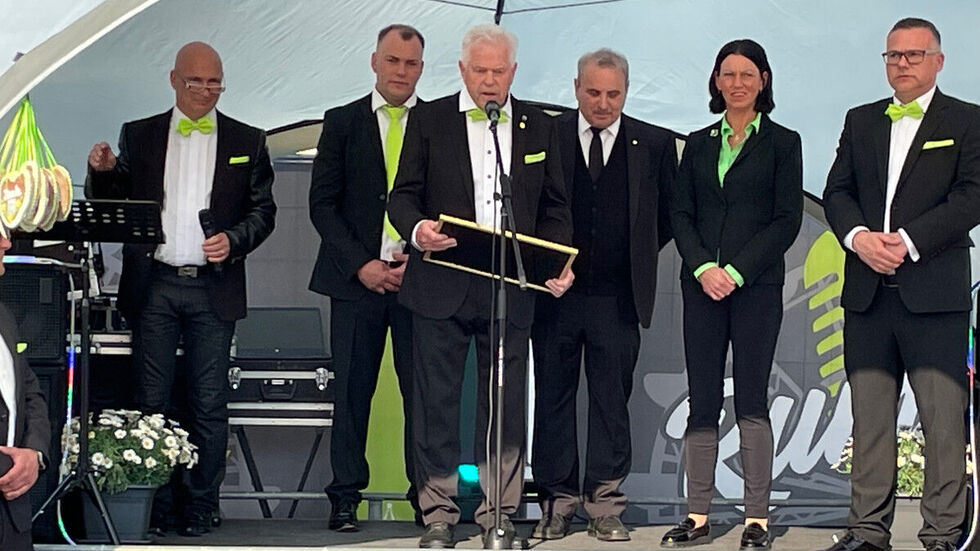 Peter Walz (am Micro) umringt von seiner Familie und dem Chef des Deutschen Schaustellerbundes, Albert Ritter (3.v.r.).  