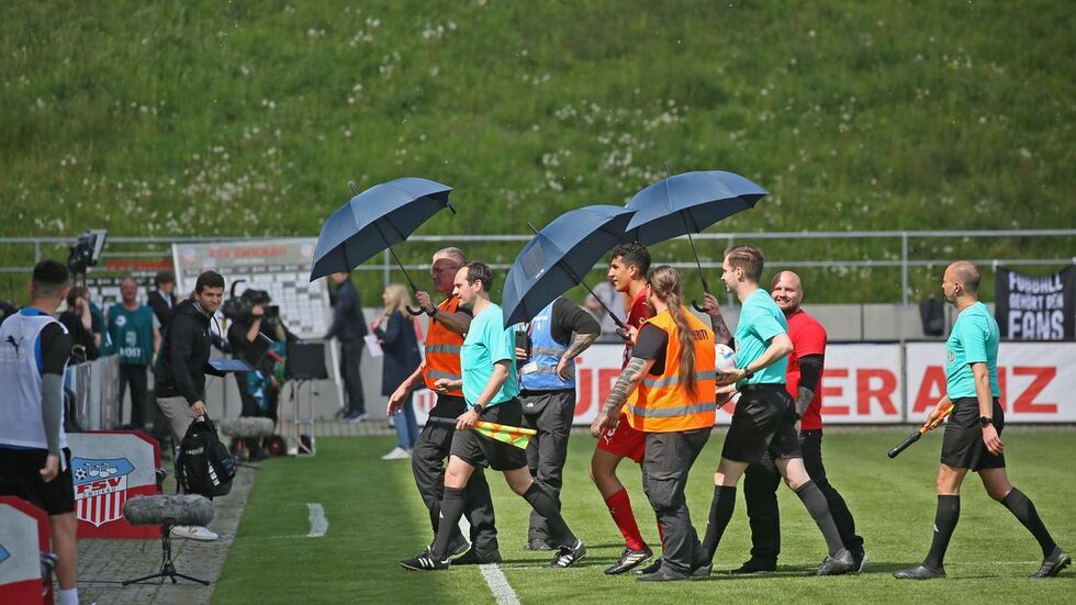 Nach der Bierdusche vor zwei Wochen wurden die Schiedsrichter diesmal mit Schirmen vor Übergriffen geschützt. Nach der Bierdusche vor zwei Wochen wurden die Schiedsrichter diesmal mit Schirmen vor Übergriffen geschützt.