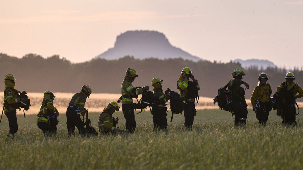 Freiwillige Feuerwehrleute des Internationalen Katastrophenschutz Deutschland "@fire", im Hintergrund ist der Lilienstein zu sehen. Freiwillige Feuerwehrleute des Internationalen Katastrophenschutz Deutschland "@fire", im Hintergrund ist der Lilienstein zu sehen.